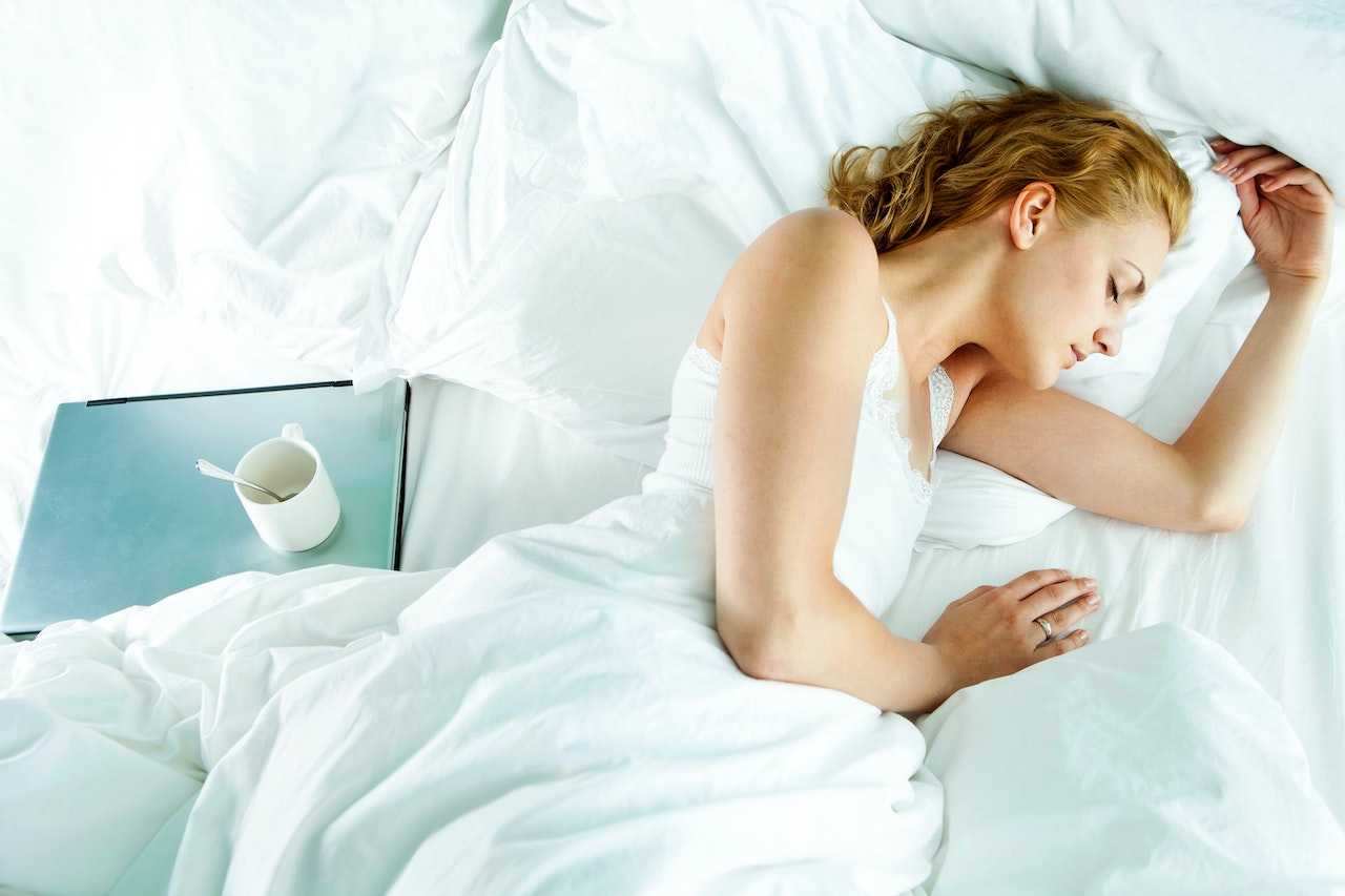 Woman lying awake in bed at night with eyes open, showing trouble sleeping